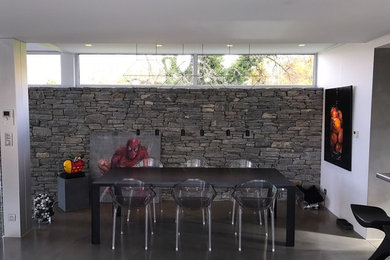 Inspiration pour une grande salle à manger ouverte sur le salon design avec un mur gris, sol en béton ciré et aucune cheminée.