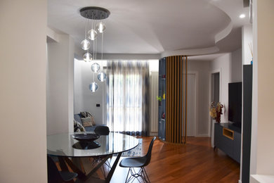 Imagen de comedor moderno de tamaño medio cerrado con paredes azules, suelo de madera clara y bandeja