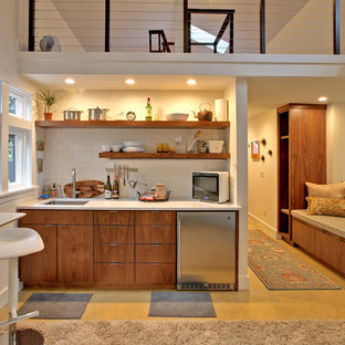 Неиссякаемый источник вдохновения для домашнего уюта: маленькая линейная кухня-гостиная в современном стиле с плоскими фасадами, темными деревянными фасадами, столешницей из кварцевого композита, белым фартуком, фартуком из плитки кабанчик, техникой из нержавеющей стали, бетонным полом, врезной раковиной и желтым полом без острова