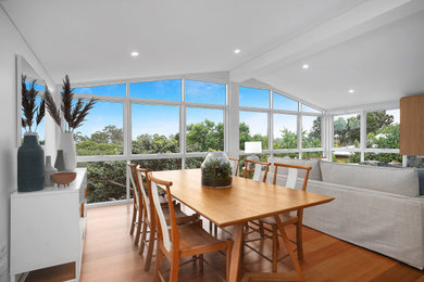 Design ideas for a mid-sized contemporary open plan dining in Brisbane with white walls and brown floor.