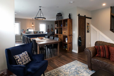Example of a large mountain style open concept laminate floor and brown floor family room design in Other with gray walls, a standard fireplace, a tile fireplace and no tv