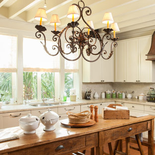 Kitchen - small beach style l-shaped medium tone wood floor kitchen idea in Charleston with a double-bowl sink, recessed-panel cabinets, beige cabinets and an island
