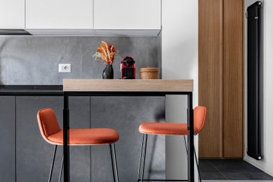 Foto di una cucina ad ambiente unico design di medie dimensioni con pavimento in gres porcellanato, pavimento grigio e top nero