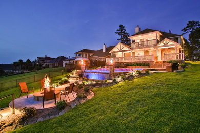 Inspiration for a large traditional backyard stone landscaping in Houston with a fire pit.