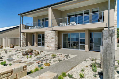 Large beach style two-storey multi-coloured apartment exterior in Adelaide with stone veneer and a metal roof.