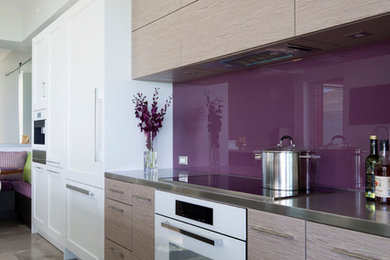 Kitchen - modern concrete floor and gray floor kitchen idea in Hawaii with flat-panel cabinets, beige cabinets, stainless steel countertops and glass sheet backsplash