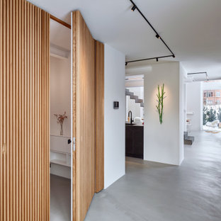Großer Moderner Eingang mit Foyer, weißer Wandfarbe, Betonboden und grauem Boden in Düsseldorf