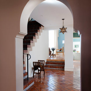 Inredning av en eklektisk stor foajé, med flerfärgade väggar, tegelgolv och en dubbeldörr