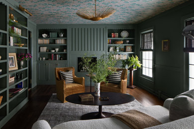 Modelo de sala de estar cerrada tradicional renovada con paredes verdes, suelo de madera oscura, todas las chimeneas, suelo marrón y papel pintado