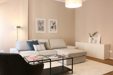 Immagine di un piccolo soggiorno contemporaneo aperto con pareti beige, pavimento in legno massello medio e pavimento marrone