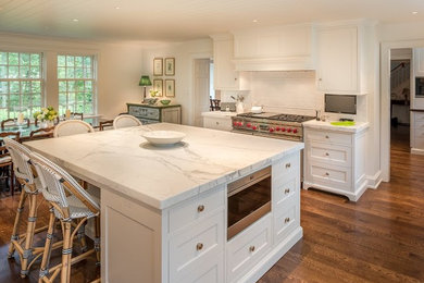 Eat-in kitchen - large traditional dark wood floor eat-in kitchen idea in Philadelphia with a farmhouse sink, white cabinets, marble countertops, white backsplash, subway tile backsplash, stainless steel appliances, an island and beaded inset cabinets