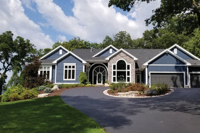 Example of a large trendy blue one-story concrete fiberboard exterior home design in Milwaukee with a shingle roof