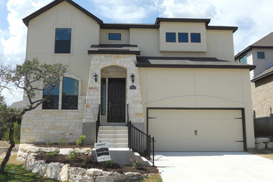 Large mountain style beige two-story adobe exterior home photo in Austin