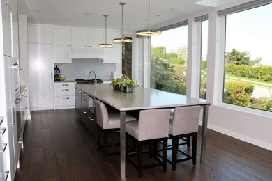 Mid-sized trendy u-shaped dark wood floor and brown floor open concept kitchen photo in Vancouver with an undermount sink, flat-panel cabinets, dark wood cabinets, granite countertops, gray backsplash, stone slab backsplash, stainless steel appliances, an island and beige countertops