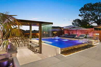 Example of a small trendy front yard tile and rectangular infinity pool design in San Diego with a bbq area