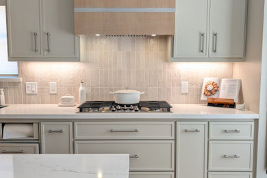 Minimalist kitchen photo in Houston with shaker cabinets, light wood cabinets, quartz countertops, beige backsplash, porcelain backsplash, an island and white countertops