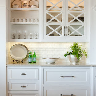 オレンジカウンティの中サイズのビーチスタイルのおしゃれなホームバー (落し込みパネル扉のキャビネット、白いキャビネット、無垢フローリング、白いキッチンパネル、シンクなし、クオーツストーンカウンター、茶色い床) の写真