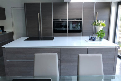 This is an example of a modern open plan kitchen in Glasgow with an island and white worktops.