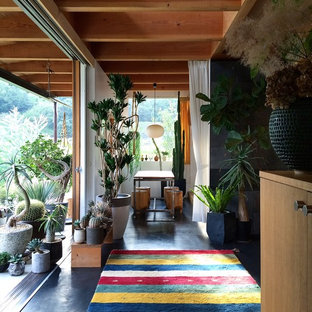 Cette image montre une petite salle à manger bohème avec aucune cheminée, un mur blanc et un sol noir.
