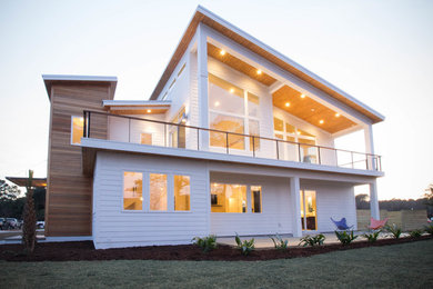 Design ideas for a mid-sized modern two-storey white exterior in Other with mixed siding and a shed roof.
