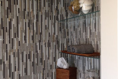 Example of a small trendy brown tile porcelain tile alcove shower design in Boston with a vessel sink, flat-panel cabinets, white cabinets, laminate countertops, a two-piece toilet and green walls