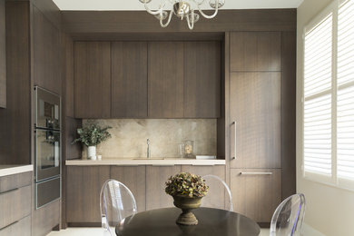 This is an example of a medium sized contemporary l-shaped kitchen/diner in London with flat-panel cabinets, dark wood cabinets, quartz worktops, stone slab splashback, stainless steel appliances, porcelain flooring and no island.