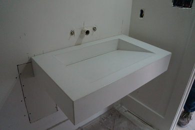 Cette photo montre une salle de bain moderne avec un plan de toilette en béton.