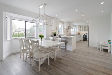 Eat-in kitchen - huge traditional galley medium tone wood floor and gray floor eat-in kitchen idea in Vancouver with an undermount sink, shaker cabinets, white cabinets, quartz countertops, white backsplash, stone slab backsplash, stainless steel appliances, a peninsula and white countertops