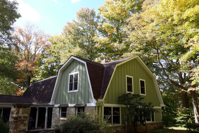 Ejemplo de fachada de casa verde tradicional pequeña de dos plantas con revestimiento de aglomerado de cemento, tejado a doble faldón y tejado de teja de madera