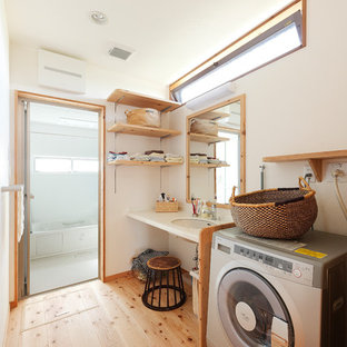 他の地域のアジアンスタイルのおしゃれなランドリールーム (白い壁、無垢フローリング、茶色い床、アンダーカウンターシンク) の写真