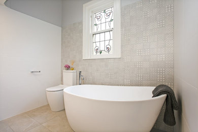 Design ideas for a mid-sized contemporary master bathroom in Melbourne with medium wood cabinets, a freestanding tub, white tile, ceramic tile, white walls, porcelain floors, a console sink, engineered quartz benchtops, beige floor, a hinged shower door, beige benchtops, a shower seat, a single vanity and a floating vanity.