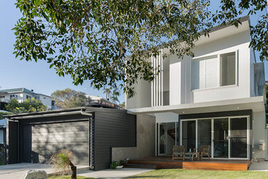 Inspiration for a small tropical two-storey white house exterior in Sunshine Coast with mixed siding and a metal roof.