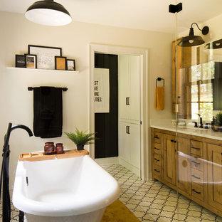 Bathroom - large transitional master white tile cement tile floor and white floor bathroom idea in Raleigh with shaker cabinets, medium tone wood cabinets, a two-piece toilet, white walls, an undermount sink, limestone countertops, a hinged shower door and white countertops