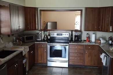 Inspiration for a mid-sized timeless u-shaped ceramic tile open concept kitchen remodel in Kansas City with an undermount sink, dark wood cabinets, granite countertops, stainless steel appliances and a peninsula