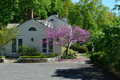 Mid-sized traditional front yard full sun driveway in New York with natural stone pavers.