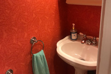ボストンにある小さなビーチスタイルのおしゃれなトイレ・洗面所 (シェーカースタイル扉のキャビネット、青いキャビネット、分離型トイレ、一体型シンク、マルチカラーの床、白い洗面カウンター、独立型洗面台) の写真