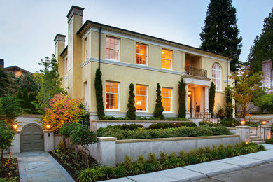 Inspiration for a timeless yellow three-story stucco exterior home remodel in Seattle