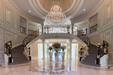 Huge elegant wooden curved metal railing and wood wall staircase photo in DC Metro with wooden risers