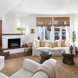 Imagen de salón para visitas abierto, mediterráneo, de tamaño medio, con paredes blancas, suelo de baldosas de terracota, chimenea de esquina y marco de chimenea de yeso