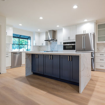 Modern White Shaker Kitchen with Navy Blue Island and Waterfall Quartz Counterto