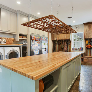 Diseño de lavadero de estilo americano con armarios estilo shaker, puertas de armario grises, encimera de madera, paredes grises, lavadora y secadora juntas y encimeras beige