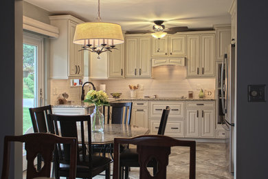 Mid-sized elegant u-shaped ceramic tile and gray floor eat-in kitchen photo in Huntington with an undermount sink, granite countertops, white backsplash, ceramic backsplash, stainless steel appliances, raised-panel cabinets, white cabinets and no island