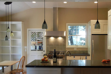Photo of a mid-sized arts and crafts u-shaped eat-in kitchen in San Francisco with shaker cabinets, white cabinets, stainless steel appliances, medium hardwood floors and a peninsula.