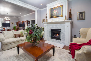 Example of a large transitional formal and open concept medium tone wood floor and brown floor living room design in Oklahoma City with gray walls, a standard fireplace, a tile fireplace and no tv