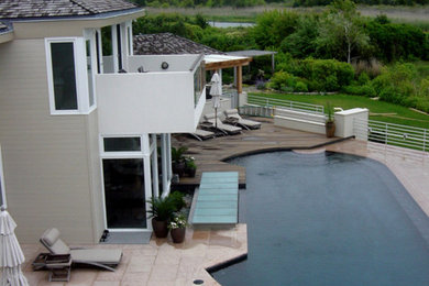 Inspiration for a large modern beige two-story mixed siding exterior home remodel in New York with a clipped gable roof