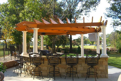 Large contemporary backyard patio in Other with an outdoor kitchen, natural stone pavers and a pergola.
