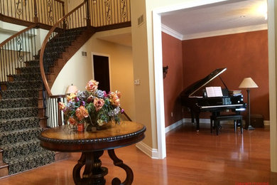This is an example of a large traditional foyer in Other with yellow walls and medium hardwood floors.