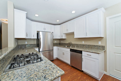 Inspiration for a mid-sized timeless u-shaped dark wood floor eat-in kitchen remodel in San Diego with a drop-in sink, shaker cabinets, white cabinets, granite countertops, stainless steel appliances and no island