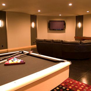 Réalisation d'une salle de cinéma design de taille moyenne et fermée avec un mur beige, béton au sol et un téléviseur fixé au mur.