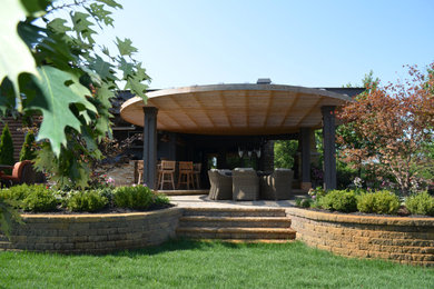 Example of a mid-sized trendy backyard concrete paver patio kitchen design in Columbus with a pergola